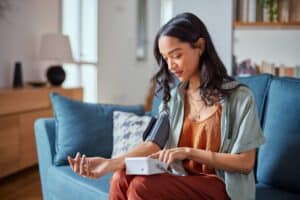 women taking blood pressure reading at home